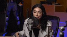 a woman wearing headphones is sitting in front of a microphone with the word justice visible in the background