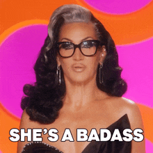 a woman with glasses and the words she 's a badass on the bottom