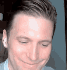 a close up of a man 's face with ear buds in his ears