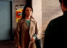 a woman stands in front of a poster that says boxing