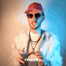 a man wearing sunglasses a fur coat and a hat with the word mcdh on the bottom