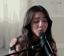 a woman is singing into a microphone and making a funny face .