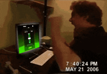a man playing a video game on a computer with the time 7:40:24 pm on may 21 2006