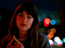 a woman wearing a ring on her finger is looking at the camera