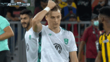 a soccer player in a green and white shirt with the letter g on it