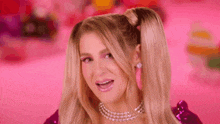 a close up of a woman wearing a ponytail and a pearl choker .