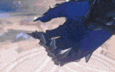a person wearing a blue glove with spikes on the fingers