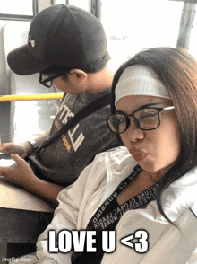 a woman wearing glasses is sitting next to a man wearing a hat and the words love u < 3
