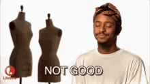 a man wearing a headband and a white shirt is standing in front of three mannequins and saying not good .