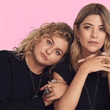 two women are posing for a picture and one is wearing a ring on her finger