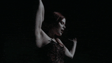 a woman in a corset is dancing in the dark