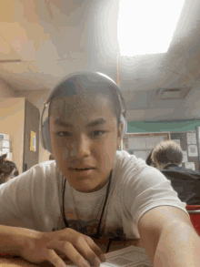a boy wearing headphones looks at the camera with a serious look on his face