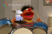 ernie from sesame street is playing drums in front of a sign that says audiobox