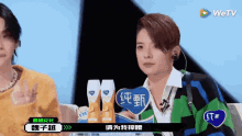 a man and a woman are sitting in front of a sign that says wetv on it