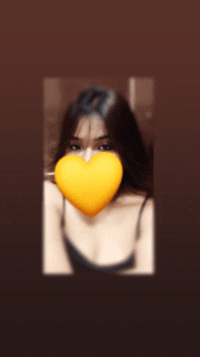 a blurry picture of a woman with a yellow heart in front of her face