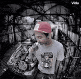 a man wearing a red hat and a t-shirt with a cartoon character on it smoking a cigarette