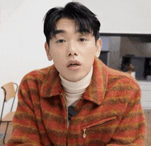 a man wearing a plaid jacket and a white turtleneck