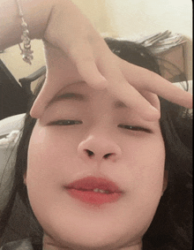 a girl with a bracelet on her wrist holds her hand to her face