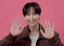 a man wearing a brown jacket and a white shirt is waving