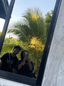 a man and a woman are taking a picture of themselves in a window