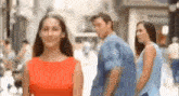 a man and a woman are walking down a street .