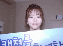a woman holds up a sign that says ' korean ' on it in front of her face