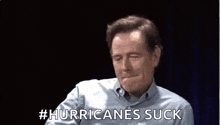 a man is making a funny face and saying `` hurricanes suck '' with his hand .