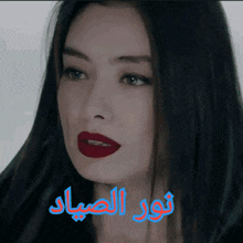 a close up of a woman 's face with red lipstick and arabic writing