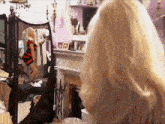 a woman is standing in front of a mirror and looking at herself
