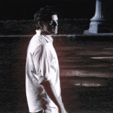 a man in a white shirt stands in front of a sign that says tda