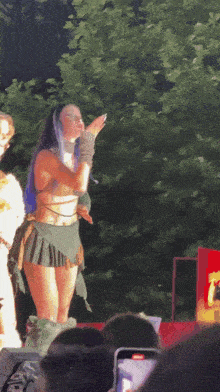 a woman blowing a kiss while wearing a green skirt