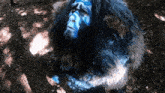 a person with blue paint on their face is laying in the woods