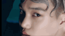 a close up of a young man 's face with gray hair and a red lip .