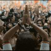 a woman in handcuffs is praying in front of a crowd and the name sanjo_sebi is on the bottom