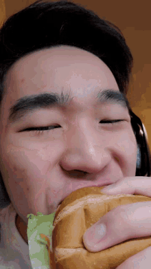 a close up of a person eating a sandwich