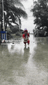 a person in a santa claus costume is walking in the rain