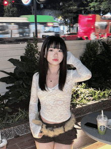 a girl standing in front of a starbucks cup with a straw
