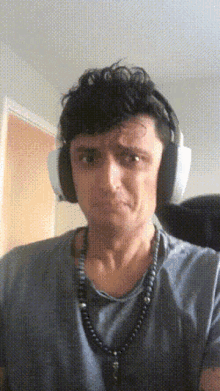 a man wearing headphones and a necklace with a cross