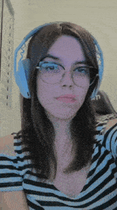 a woman wearing glasses and headphones is looking at the camera