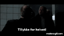 a man with a beard is standing in a bathroom with his hand on his chest and the words `` tillykke for helvet '' .