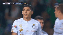 a soccer player stands in front of a screen that says cruz azul
