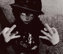 a black and white photo of a young boy wearing a hat and a black hoodie .