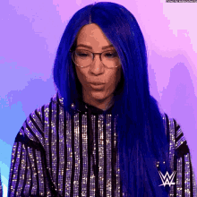 a woman with blue hair is wearing glasses and a striped top