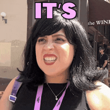 a woman wearing a lanyard that says it 's on it is smiling
