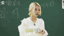 a girl in a white shirt is sitting at a desk with a notebook and a bottle of water in front of her