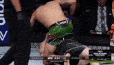 a fighter wearing green shorts with the word venum on it