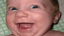 a baby is making a funny face with his mouth open .