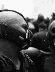 a man wearing a gas mask is standing in a crowd .