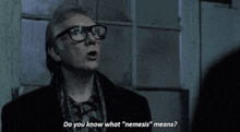 a man wearing glasses says do you know what nemesis " means "