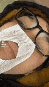 a close up of a person wearing glasses and a mask that says tiktok on the bottom